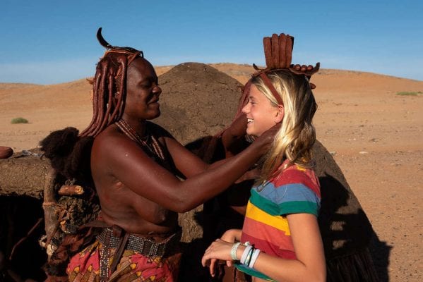 HImba lady putting necklace on visitor